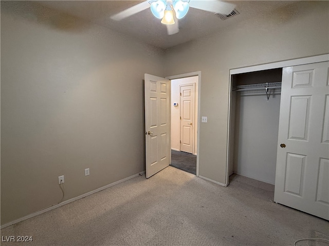 unfurnished bedroom featuring light colored carpet, a closet, and ceiling fan