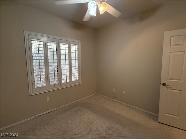 carpeted spare room with ceiling fan