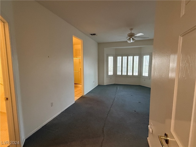 carpeted spare room featuring ceiling fan