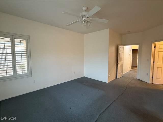 empty room with dark carpet and ceiling fan