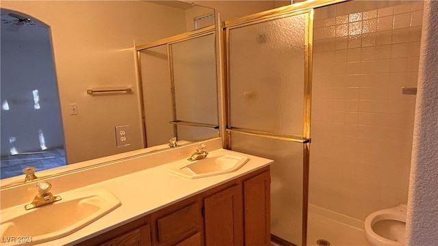 bathroom with walk in shower, vanity, and toilet