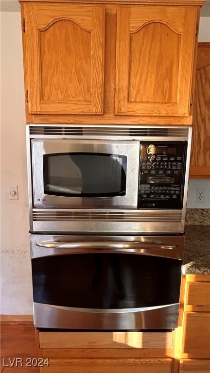 room details with stainless steel appliances and dark stone countertops