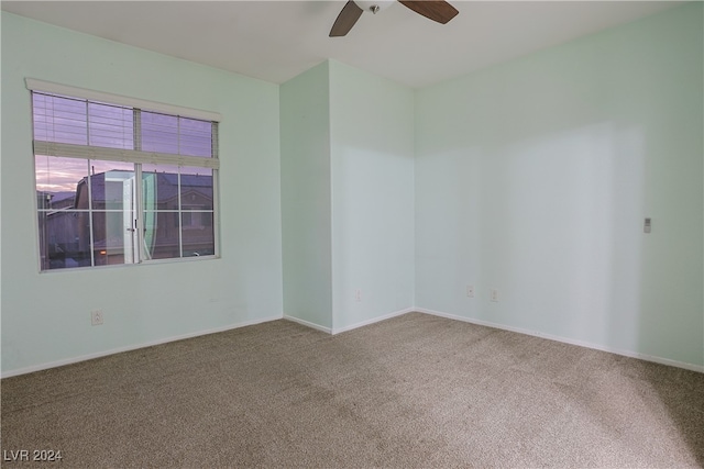 carpeted spare room featuring ceiling fan