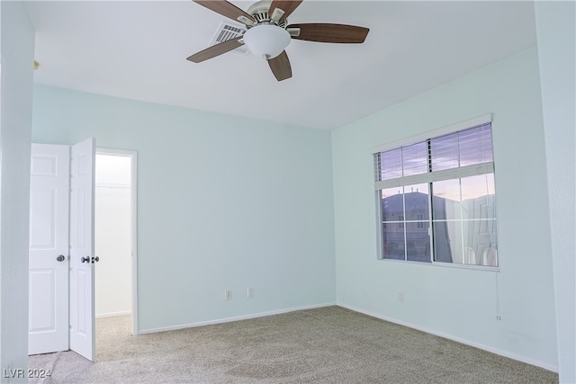 spare room featuring light colored carpet and ceiling fan