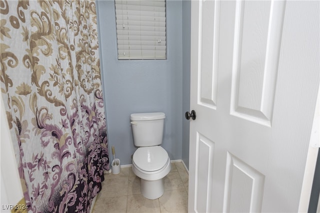 bathroom featuring toilet, walk in shower, and tile patterned floors