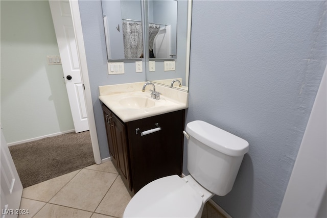 bathroom with toilet, vanity, and tile patterned floors