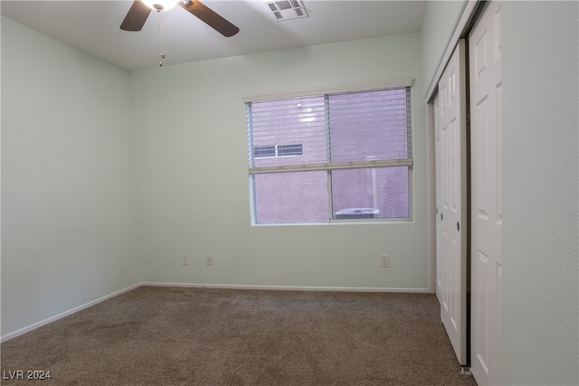 carpeted empty room featuring ceiling fan