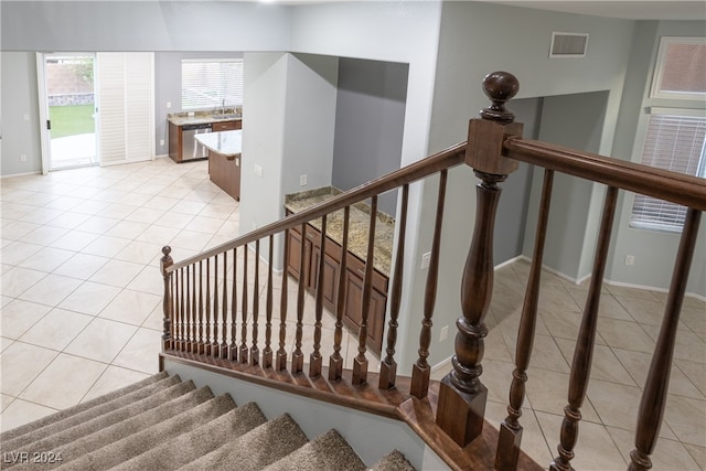 stairs with tile patterned floors and sink