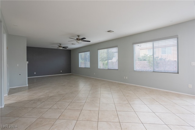 spare room with ceiling fan and light tile patterned floors