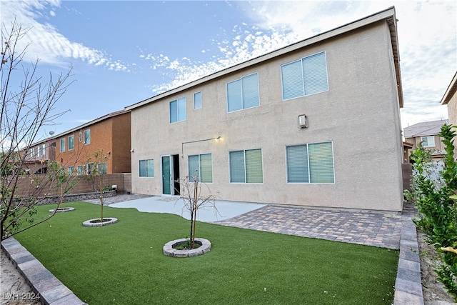 back of house with a yard and a patio