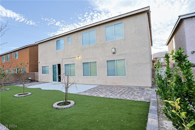 back of property featuring an outdoor fire pit, a patio, and a lawn