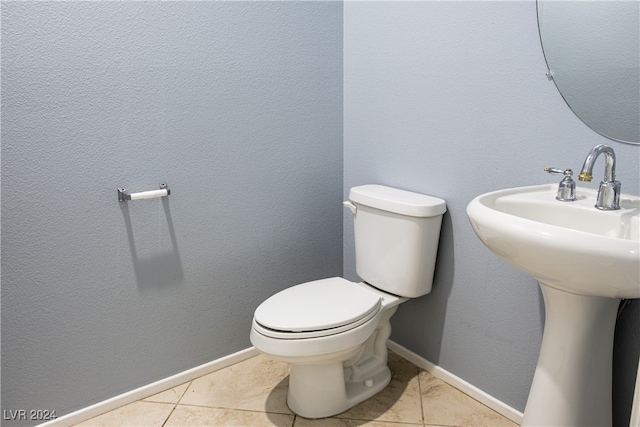 bathroom featuring toilet, tile patterned floors, and sink