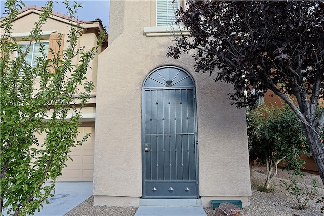 doorway to property with a garage