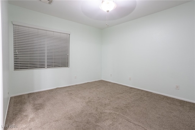 carpeted spare room featuring ceiling fan