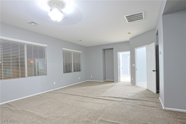 carpeted spare room featuring ceiling fan