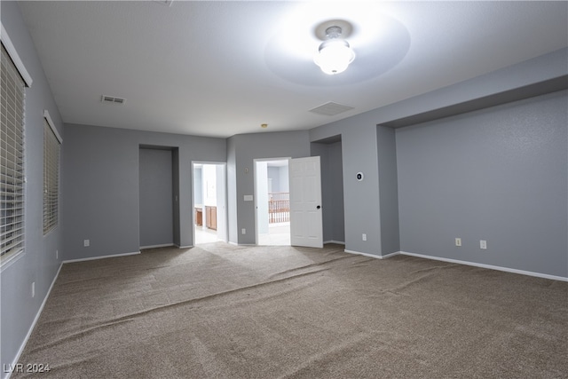 unfurnished bedroom featuring ensuite bathroom and carpet