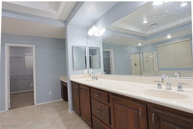 bathroom featuring vanity, a shower with shower door, a raised ceiling, and tile patterned flooring