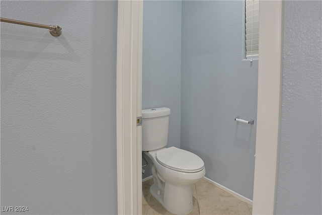 bathroom with toilet and tile patterned flooring