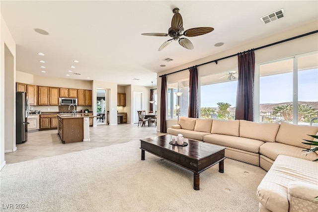 living room with sink, a healthy amount of sunlight, light tile patterned floors, and ceiling fan