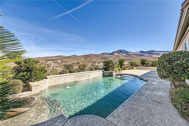 view of swimming pool with a mountain view and pool water feature