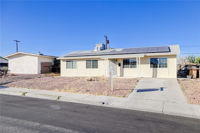 ranch-style house featuring solar panels