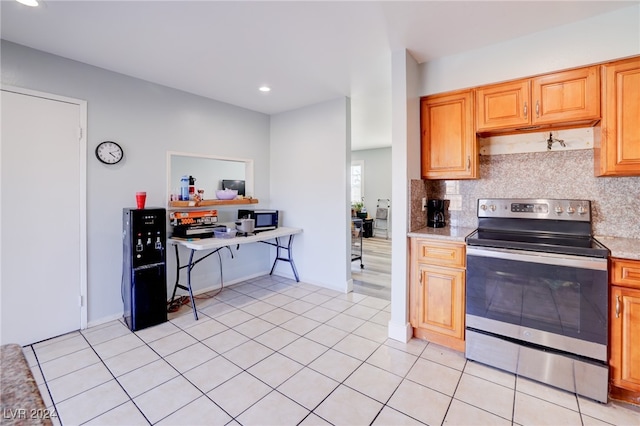 kitchen with backsplash, appliances with stainless steel finishes, and light tile patterned flooring