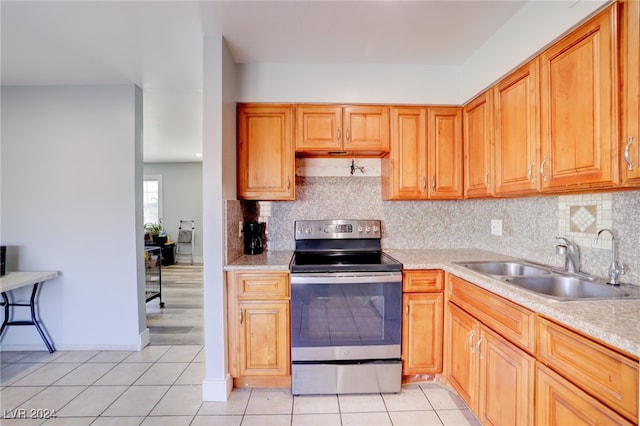 kitchen with tasteful backsplash, stainless steel range with electric cooktop, sink, and light tile patterned floors