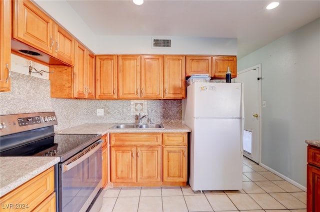 kitchen with white refrigerator, sink, tasteful backsplash, light tile patterned floors, and electric stove