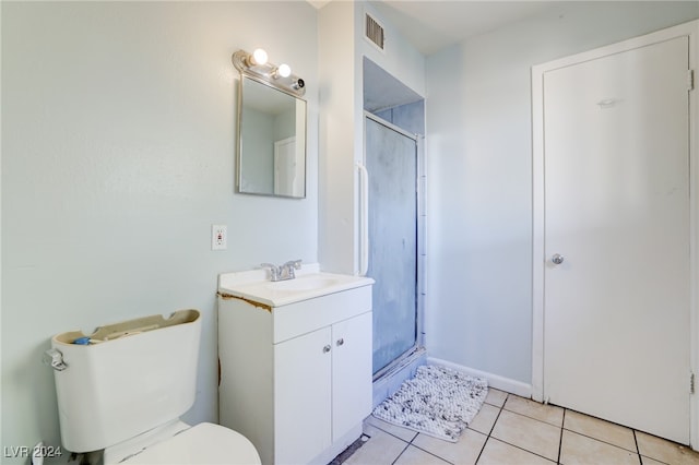 bathroom with vanity, toilet, tile patterned floors, and a shower with door