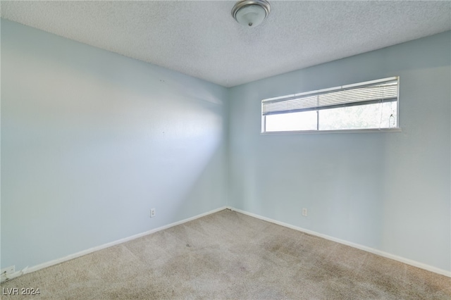 carpeted spare room featuring a textured ceiling