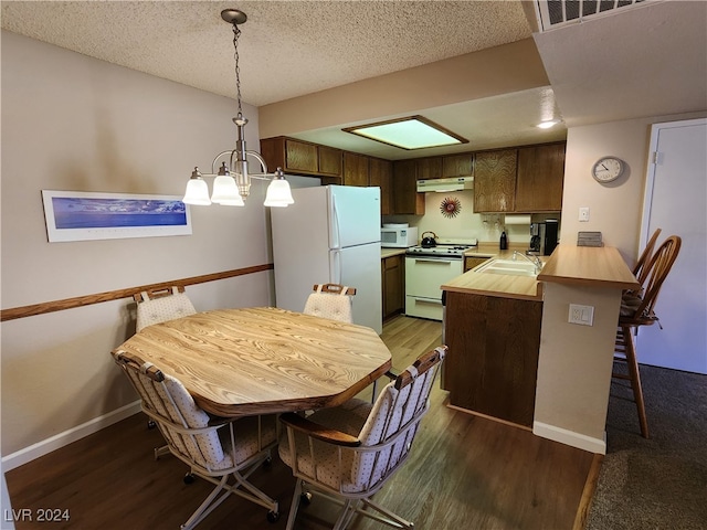 dining room with a textured ceiling, wood-type flooring, and sink