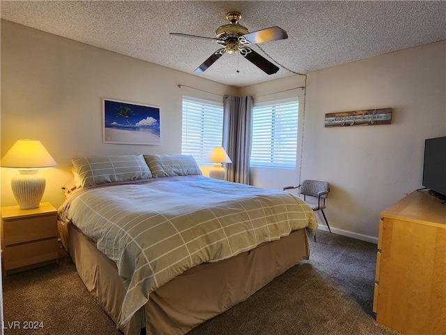 bedroom with a textured ceiling, dark carpet, and ceiling fan