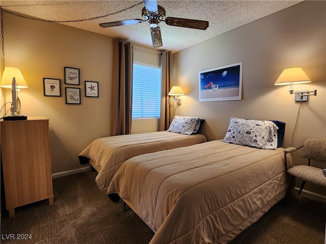 bedroom with a textured ceiling, dark carpet, and ceiling fan