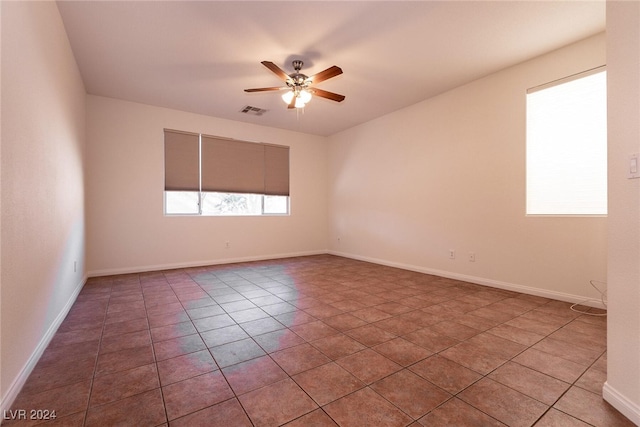 tiled spare room with ceiling fan