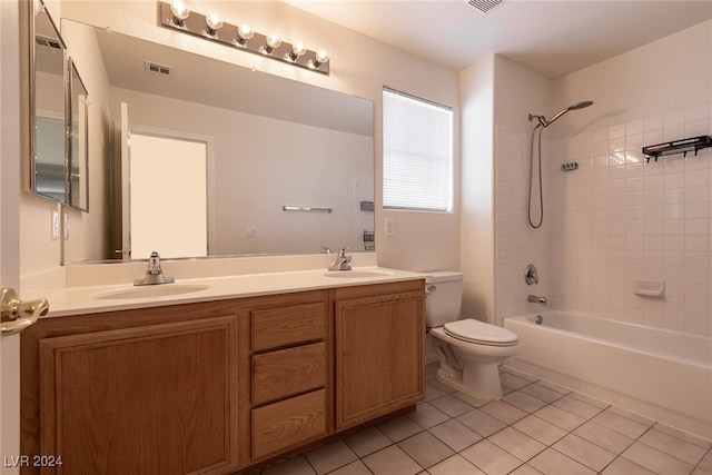 full bathroom featuring tile patterned floors, vanity, tiled shower / bath combo, and toilet