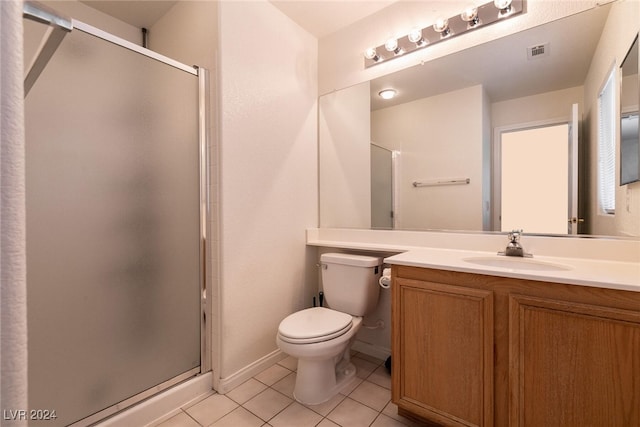 bathroom featuring toilet, vanity, tile patterned floors, and walk in shower