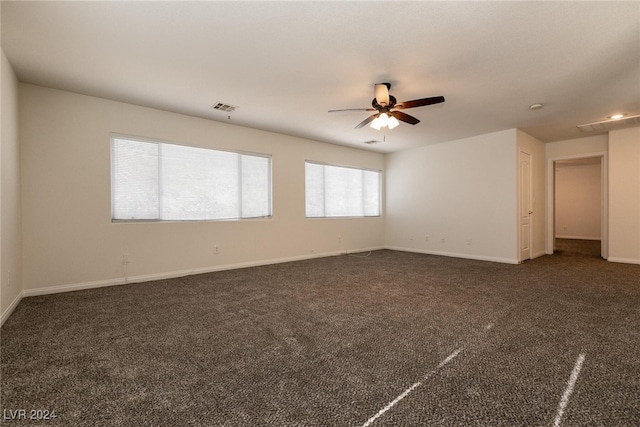 empty room with ceiling fan and dark carpet