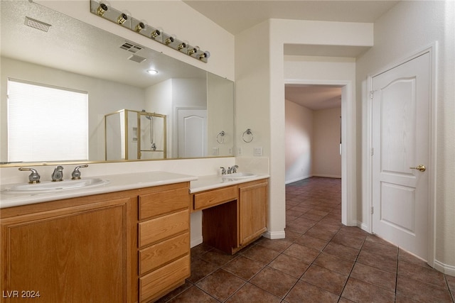 bathroom featuring tile patterned flooring, vanity, and a shower with door