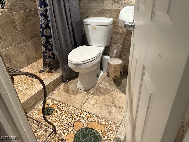 bathroom featuring toilet, tile walls, and walk in shower