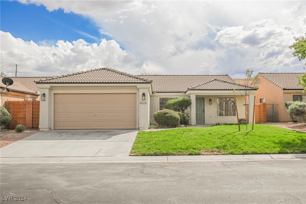 mediterranean / spanish home with a front lawn and a garage