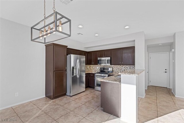 kitchen with tasteful backsplash, hanging light fixtures, dark brown cabinetry, light stone counters, and stainless steel appliances