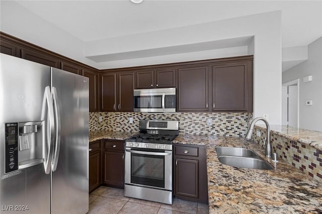 kitchen featuring light stone countertops, appliances with stainless steel finishes, sink, and decorative backsplash