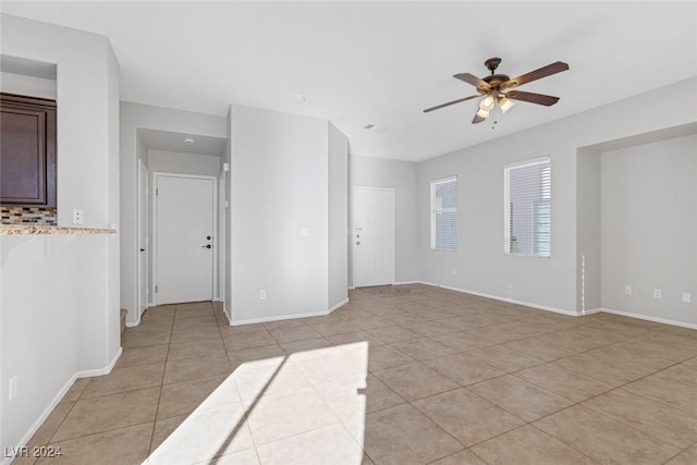 tiled spare room with ceiling fan