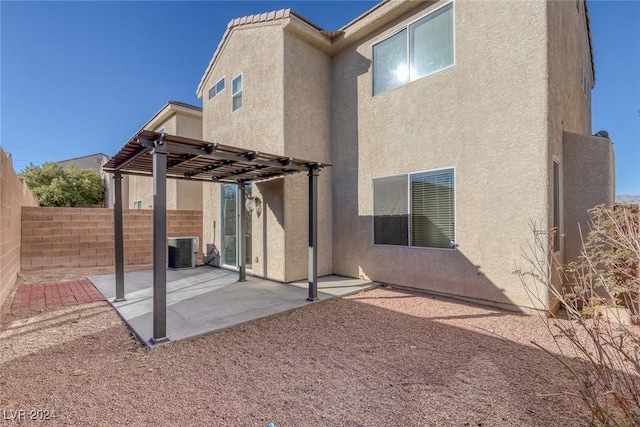 rear view of house with central AC, a pergola, and a patio area