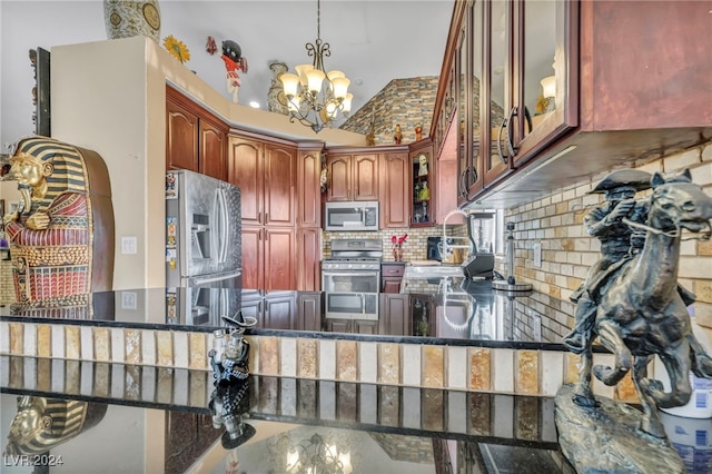 kitchen featuring kitchen peninsula, decorative light fixtures, stainless steel appliances, and tasteful backsplash