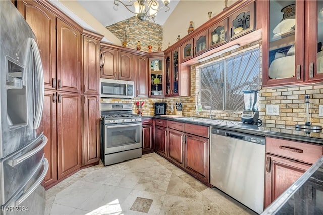 kitchen featuring appliances with stainless steel finishes, a chandelier, high vaulted ceiling, and backsplash