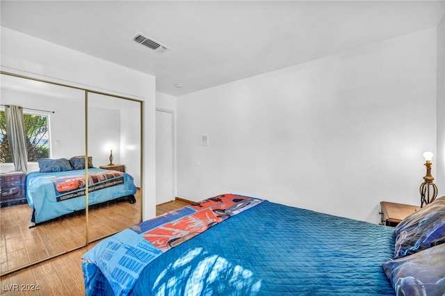 bedroom with hardwood / wood-style floors and a closet