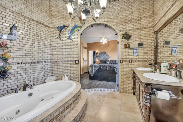 bathroom featuring vanity, tile patterned flooring, brick wall, and tiled bath