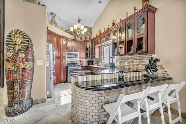 kitchen with decorative backsplash, kitchen peninsula, decorative light fixtures, a chandelier, and appliances with stainless steel finishes