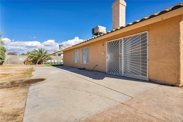 view of side of home featuring a patio and central AC unit